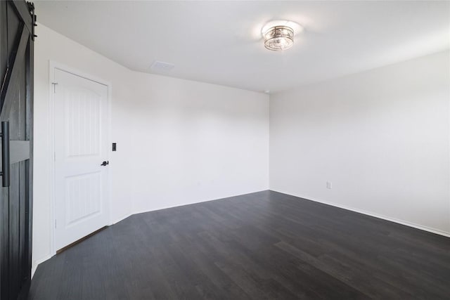 12024 Roving Pass, Elgin, TX 78621 - unfurnished room with dark wood-style flooring, a barn door, and baseboards