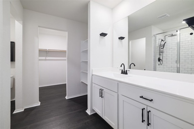 12024 Roving Pass, Elgin, TX 78621 - full bath featuring wood finished floors, a spacious closet, a stall shower, vanity, and baseboards