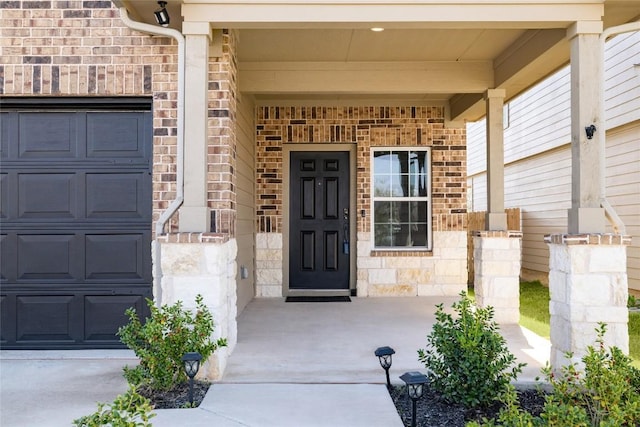 12024 Roving Pass, Elgin, TX 78621 - property entrance featuring a porch, an attached garage, brick siding, and stone siding
