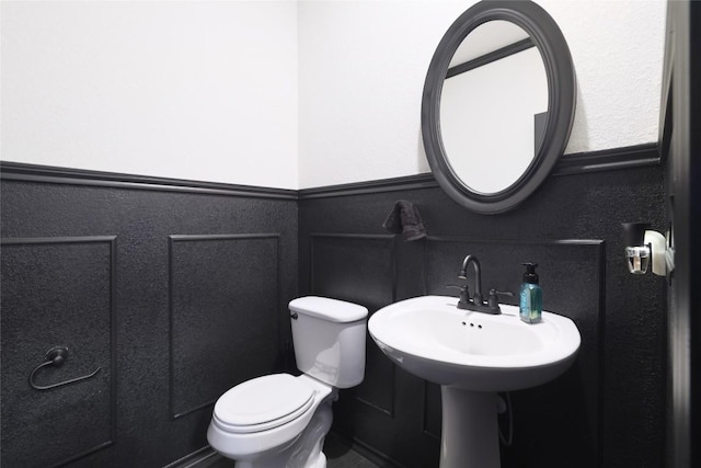 12024 Roving Pass, Elgin, TX 78621 - bathroom featuring wainscoting, toilet, and a decorative wall