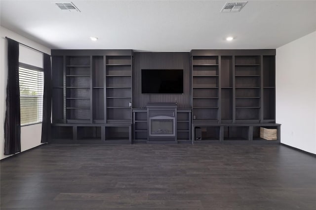 12024 Roving Pass, Elgin, TX 78621 - unfurnished living room featuring dark wood-type flooring, a fireplace, recessed lighting, baseboards, and built in shelves