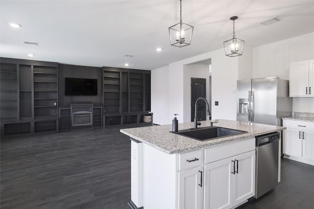 12024 Roving Pass, Elgin, TX 78621 - kitchen with stainless steel appliances, a sink, dark wood finished floors, decorative light fixtures, and a kitchen island with sink