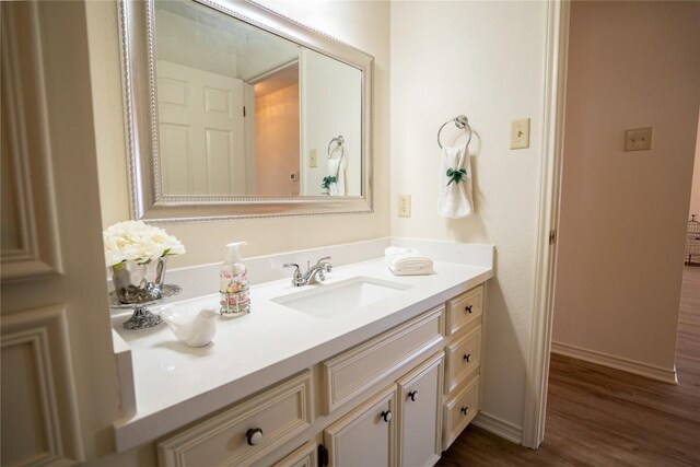 1510 Prather St, Taylor, TX 76574 - bathroom with baseboards, wood finished floors, and vanity