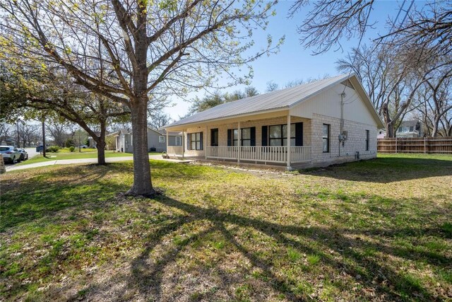 1510 Prather St, Taylor, TX 76574 - view of front of home featuring a front yard, fence, covered porch, and metal roof
