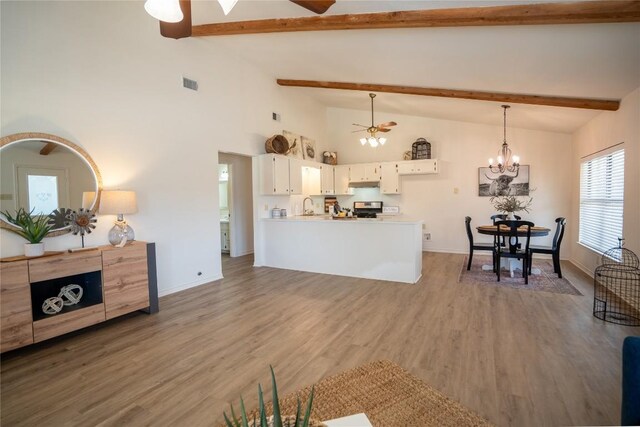 1510 Prather St, Taylor, TX 76574 - living room featuring visible vents, beam ceiling, wood finished floors, and ceiling fan with notable chandelier