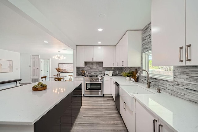 5510 Coventry Ln, Austin, TX 78723 - kitchen with appliances with stainless steel finishes, white cabinetry, backsplash, a chandelier, and recessed lighting