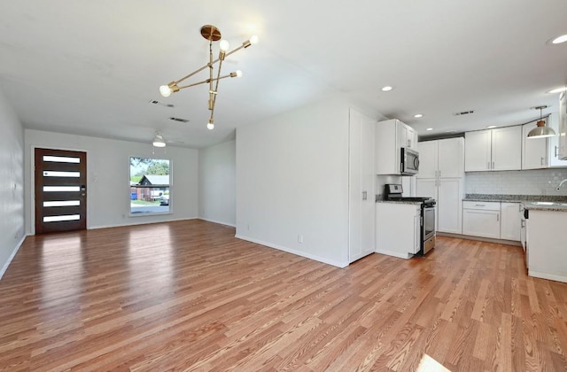 5907 Glenhollow Path, Austin, TX 78745 - unfurnished living room with light wood finished floors, a chandelier, a sink, recessed lighting, and baseboards