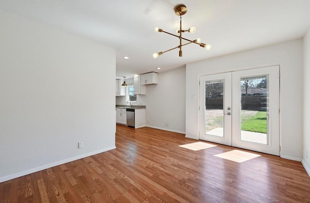 5907 Glenhollow Path, Austin, TX 78745 - unfurnished living room with a chandelier, french doors, baseboards, light wood-type flooring, and recessed lighting
