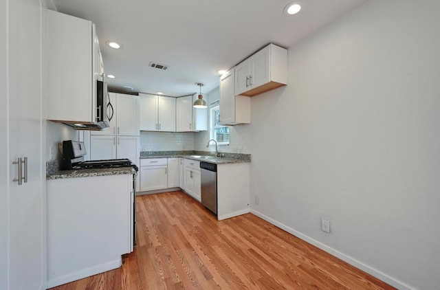 5907 Glenhollow Path, Austin, TX 78745 - kitchen with stainless steel appliances, baseboards, light wood-style floors, white cabinetry, and decorative backsplash