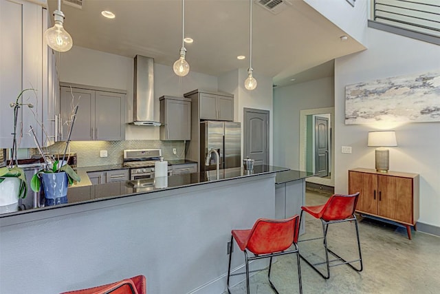 2612 Hidalgo St, Austin, TX 78702 - kitchen featuring appliances with stainless steel finishes, gray cabinetry, wall chimney exhaust hood, backsplash, and dark countertops