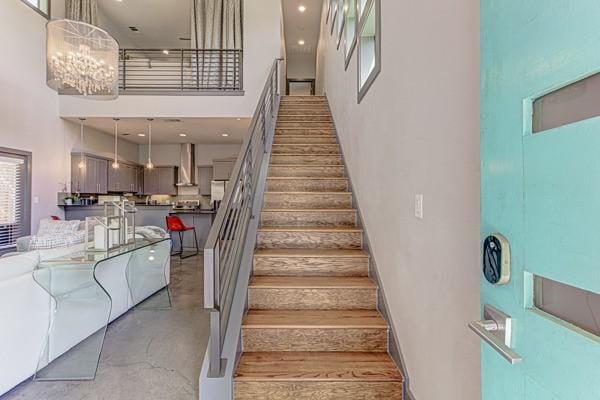 2612 Hidalgo St, Austin, TX 78702 - stairway featuring a towering ceiling, finished concrete floors, and a chandelier