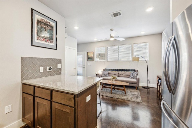 11393/4 Gunter St Unit B, Austin, TX 78721 - kitchen featuring freestanding refrigerator, finished concrete floors, ceiling fan, backsplash, and light stone countertops