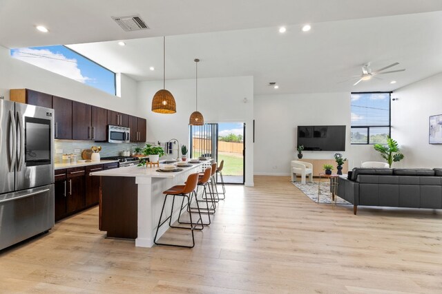 5809 Toscana Ave, Austin, TX 78724 - kitchen with stainless steel appliances, open floor plan, a kitchen breakfast bar, healthy amount of natural light, and recessed lighting