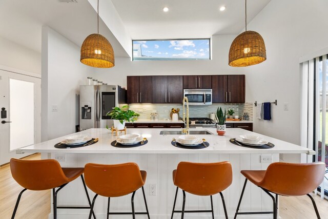 5809 Toscana Ave, Austin, TX 78724 - kitchen with stainless steel appliances, backsplash, light countertops, a sink, and dark brown cabinetry