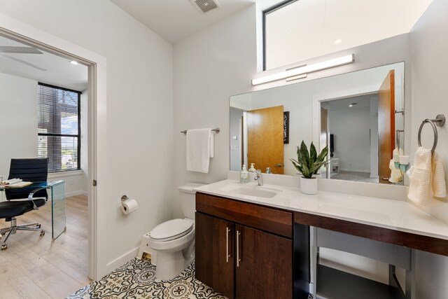 5809 Toscana Ave, Austin, TX 78724 - bathroom featuring vanity, toilet, baseboards, and wood finished floors