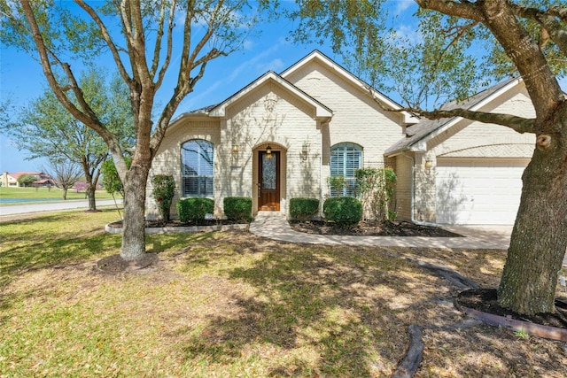 french provincial home featuring a front lawn, brick siding, and a garage