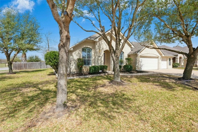 view of front of house with driveway, fence, a garage, brick siding, and a front yard