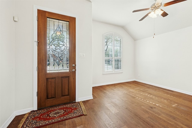 foyer with lofted ceiling, baseboards, wood finished floors, and ceiling fan
