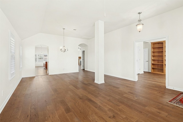 unfurnished living room featuring a chandelier, arched walkways, lofted ceiling, and dark wood-style floors