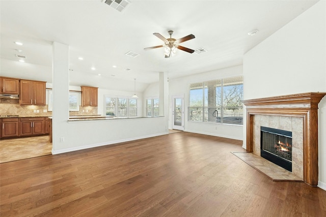 20700 Windmill Ridge St, Pflugerville, TX 78660 - unfurnished living room featuring a tiled fireplace, wood finished floors, a ceiling fan, recessed lighting, and baseboards