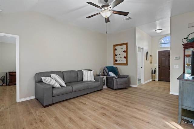 living room featuring a ceiling fan, visible vents, vaulted ceiling, baseboards, and light wood-style floors