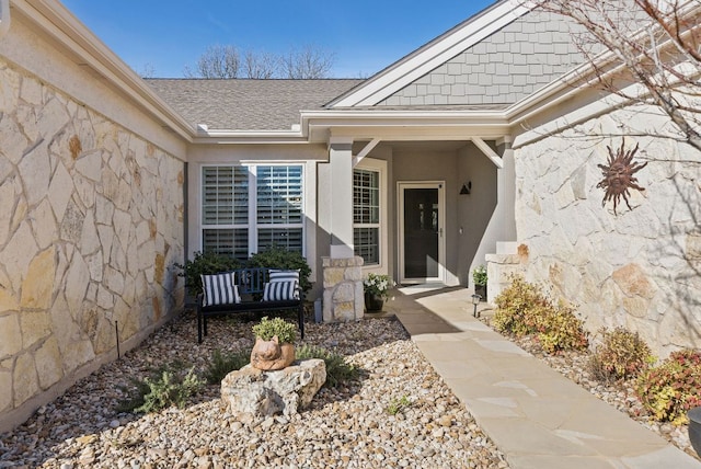 property entrance featuring stucco siding and roof with shingles