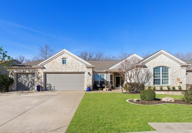 view of front facade with a front lawn, concrete driveway, roof with shingles, a garage, and stone siding