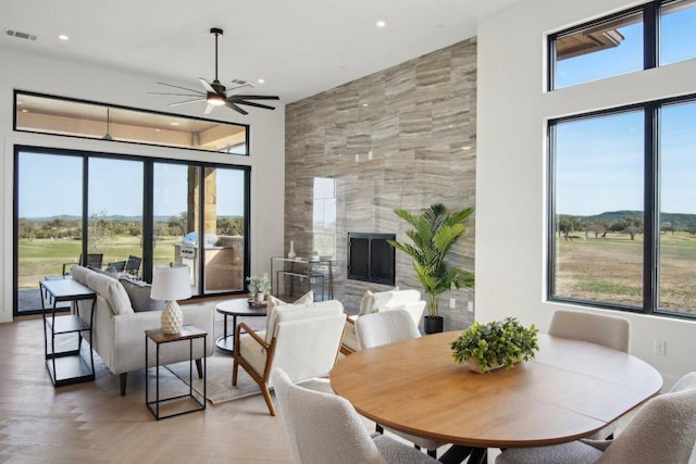 2316 Kahala Sunset Dr, Spicewood, TX 78669 - dining space featuring ceiling fan, recessed lighting, a fireplace, and a high ceiling