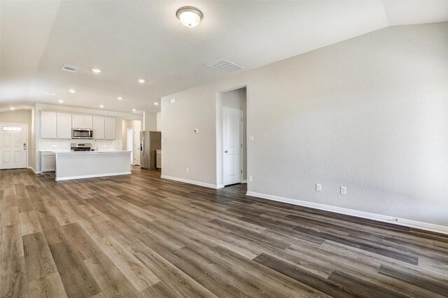 152 Greenway Ln, Georgetown, TX 78628 - unfurnished living room with vaulted ceiling, dark wood finished floors, and recessed lighting