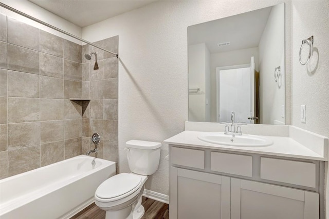 152 Greenway Ln, Georgetown, TX 78628 - full bath with wood finished floors, a textured wall, vanity, and shower / bath combination