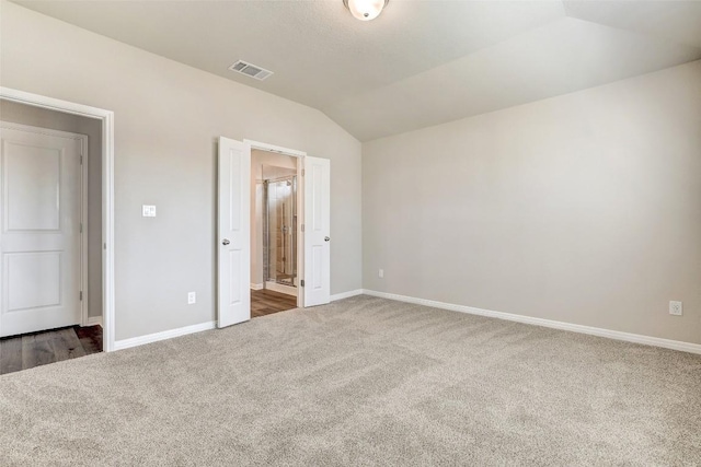 152 Greenway Ln, Georgetown, TX 78628 - unfurnished bedroom featuring carpet floors, vaulted ceiling, and connected bathroom
