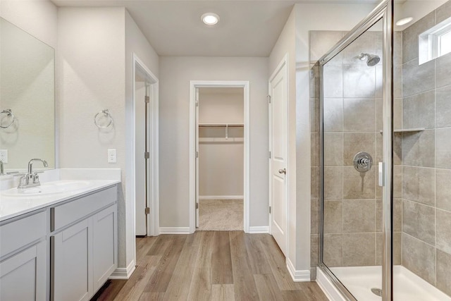 152 Greenway Ln, Georgetown, TX 78628 - full bathroom with a shower stall, vanity, wood finished floors, a spacious closet, and recessed lighting