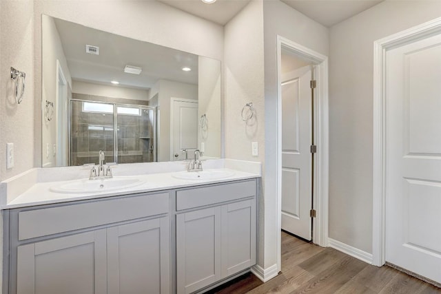 152 Greenway Ln, Georgetown, TX 78628 - bathroom featuring double vanity, a shower stall, and wood finished floors