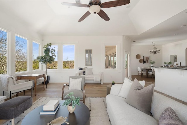 living room featuring vaulted ceiling, wood finished floors, a ceiling fan, and baseboards