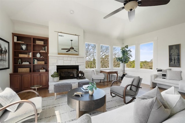 living room with a ceiling fan, wood finished floors, and a fireplace