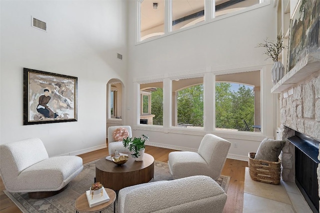 living area with wood finished floors, visible vents, and a healthy amount of sunlight