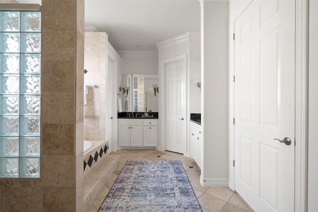 full bath featuring tiled tub, crown molding, vanity, and tile patterned floors