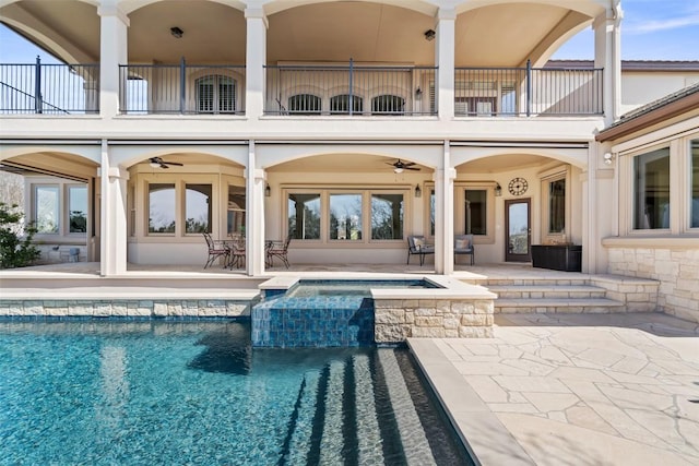 back of property with ceiling fan, a patio area, and a balcony