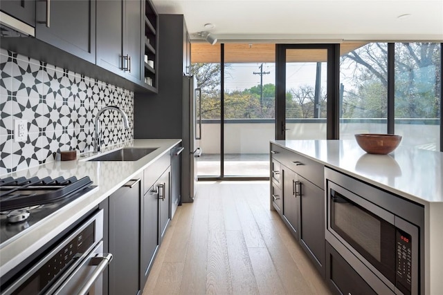 1600 S 1st St Unit 219, Austin, TX 78704 - kitchen featuring appliances with stainless steel finishes, a sink, backsplash, and light countertops