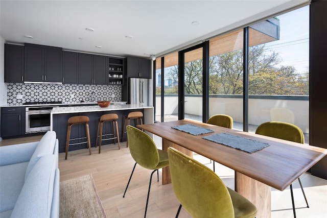 1600 S 1st St Unit 219, Austin, TX 78704 - dining space featuring light wood finished floors and a wall of windows