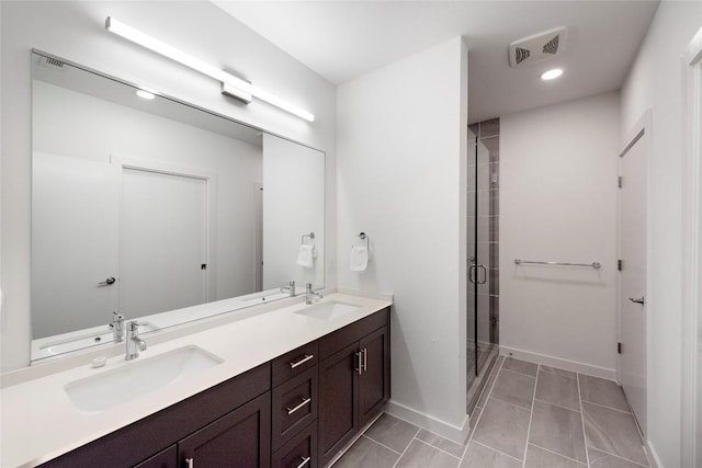 1600 S 1st St Unit 219, Austin, TX 78704 - full bath featuring double vanity, a shower stall, recessed lighting, baseboards, and tile patterned flooring
