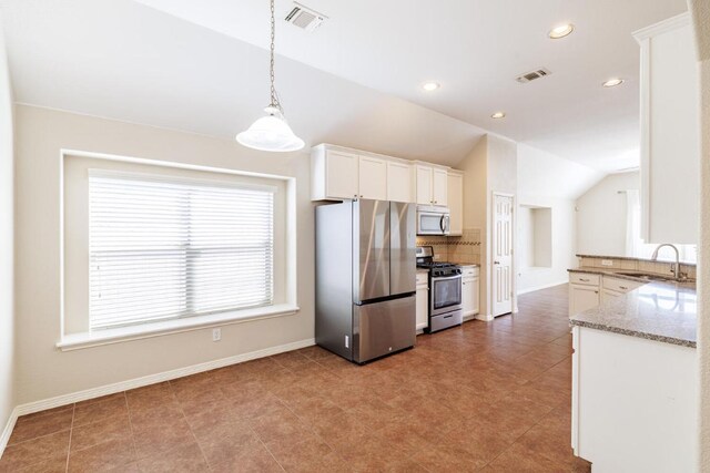 2532 Santa Barbara Loop, Round Rock, TX 78665 - kitchen featuring appliances with stainless steel finishes, a sink, vaulted ceiling, tasteful backsplash, and white cabinets