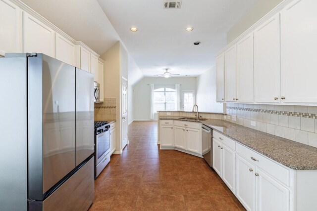 2532 Santa Barbara Loop, Round Rock, TX 78665 - kitchen featuring stainless steel appliances, a sink, a peninsula, white cabinetry, and decorative backsplash