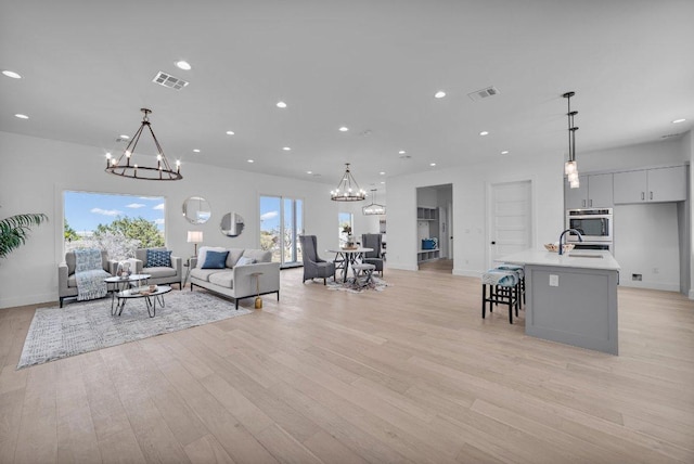 102 Mountain Home Rd, Horseshoe Bay, TX 78657 - living room featuring a chandelier, light wood-type flooring, baseboards, and recessed lighting