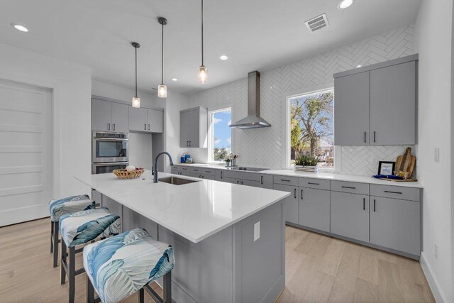 102 Mountain Home Rd, Horseshoe Bay, TX 78657 - kitchen featuring visible vents, gray cabinetry, a sink, stainless steel double oven, and wall chimney exhaust hood