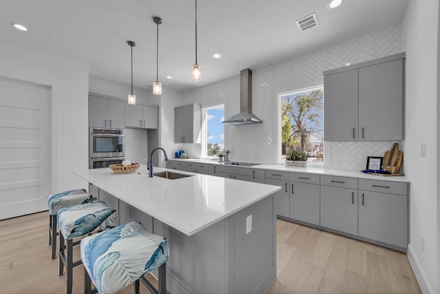 102 Mountain Home Rd, Horseshoe Bay, TX 78657 - kitchen featuring wall chimney exhaust hood, a sink, gray cabinets, stainless steel double oven, and recessed lighting