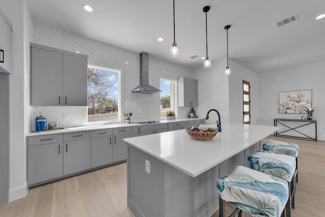 102 Mountain Home Rd, Horseshoe Bay, TX 78657 - kitchen with gray cabinets, wall chimney range hood, recessed lighting, backsplash, and light countertops