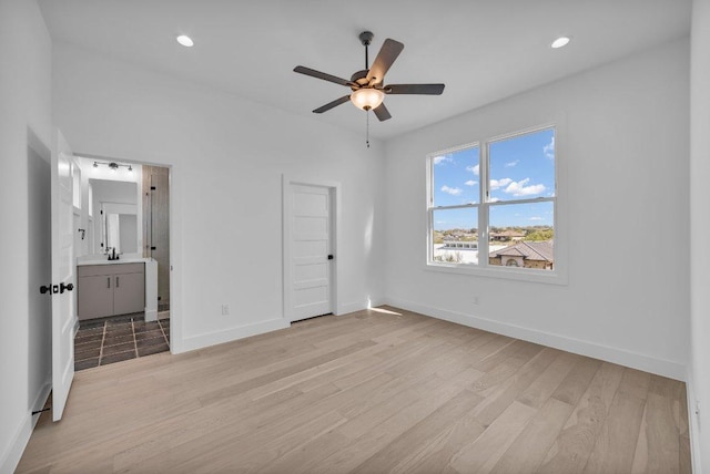 102 Mountain Home Rd, Horseshoe Bay, TX 78657 - unfurnished bedroom with light wood-style flooring, baseboards, ensuite bathroom, recessed lighting, and a ceiling fan