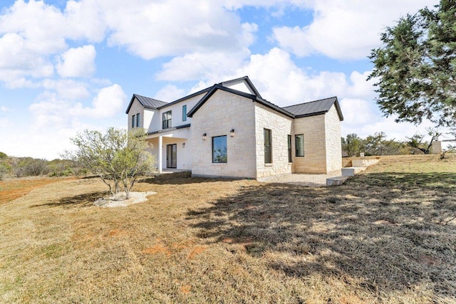 102 Mountain Home Rd, Horseshoe Bay, TX 78657 - back of house with a standing seam roof, stone siding, metal roof, and a lawn