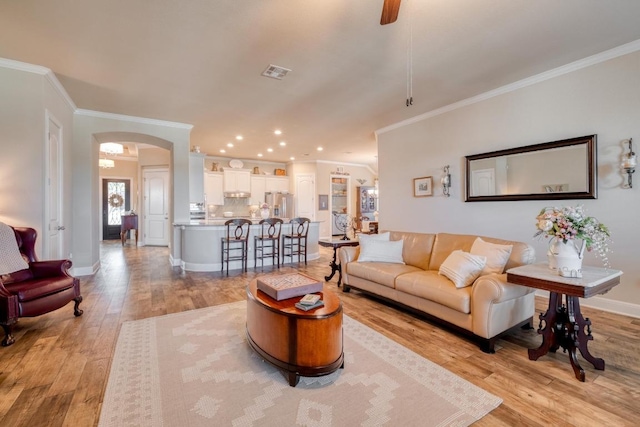 3204 Venezia Vw, Leander, TX 78641 - living room with arched walkways, crown molding, light wood-type flooring, ceiling fan, and recessed lighting